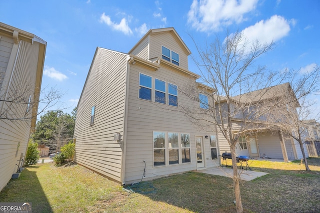 rear view of house with a patio and a lawn