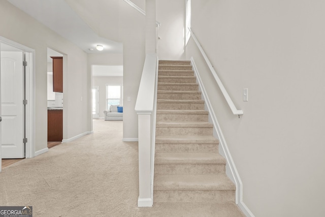 stairs with carpet floors and baseboards