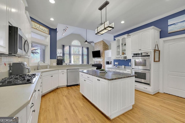 kitchen featuring a center island, white cabinets, sink, ceiling fan, and appliances with stainless steel finishes