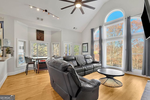 living room with light wood-type flooring, high vaulted ceiling, and ceiling fan