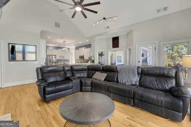 living room featuring ceiling fan, light wood-type flooring, and high vaulted ceiling