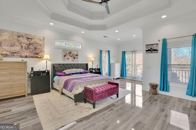 bedroom featuring a raised ceiling, ceiling fan, crown molding, and light hardwood / wood-style floors