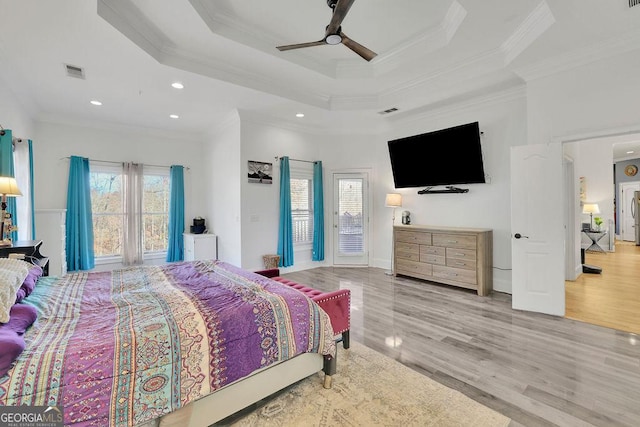 bedroom with multiple windows, a raised ceiling, ceiling fan, and crown molding