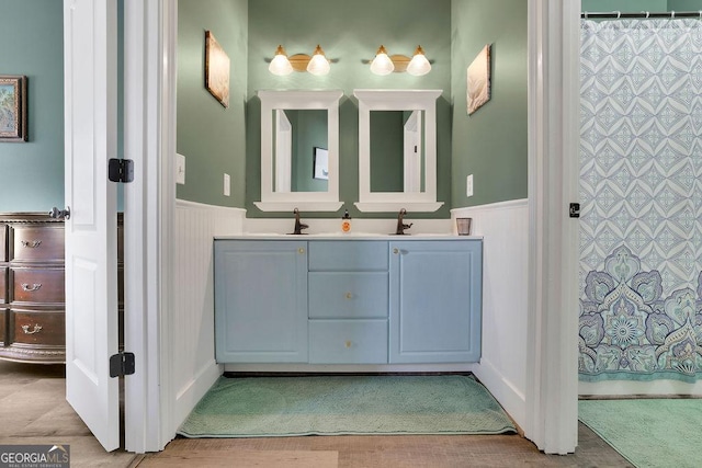 bathroom with hardwood / wood-style floors, vanity, and curtained shower