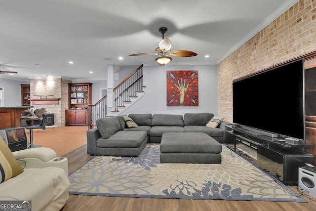 living room with hardwood / wood-style flooring, ceiling fan, ornamental molding, and brick wall