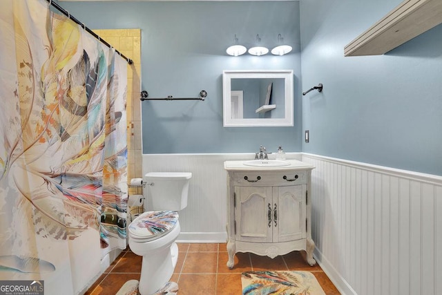 bathroom featuring toilet, vanity, tile patterned floors, and curtained shower