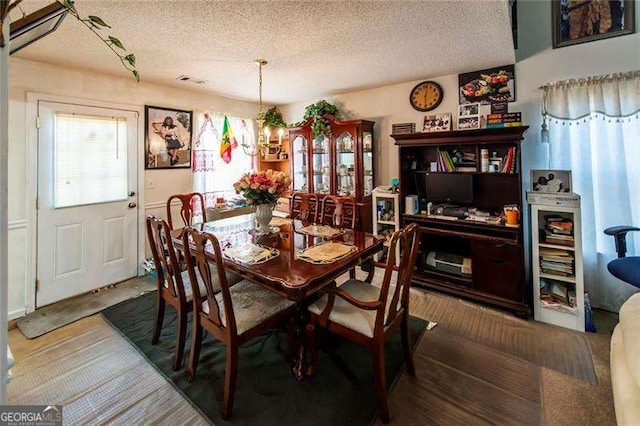 dining space featuring a textured ceiling and a chandelier