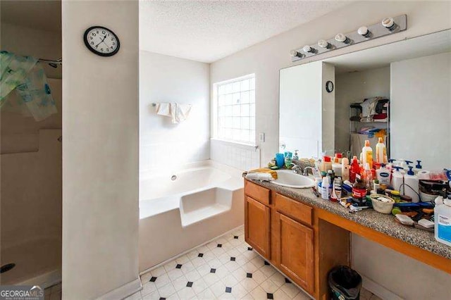 bathroom featuring vanity, a textured ceiling, and independent shower and bath