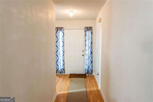 doorway with hardwood / wood-style flooring and a textured ceiling