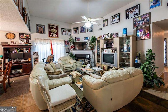 living room featuring a high ceiling, ceiling fan, and hardwood / wood-style floors