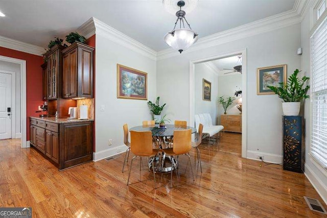 dining room featuring hardwood / wood-style floors, ceiling fan, and ornamental molding