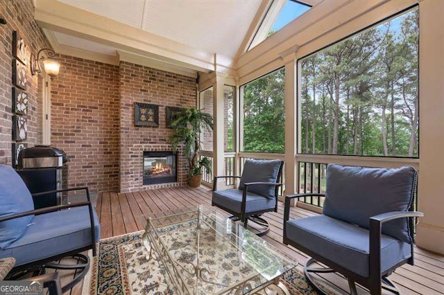 sunroom with vaulted ceiling and a brick fireplace