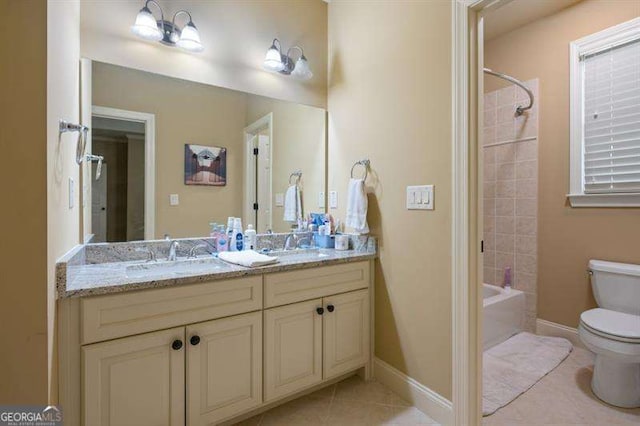 full bathroom with toilet, tile patterned flooring, vanity, and tiled shower / bath