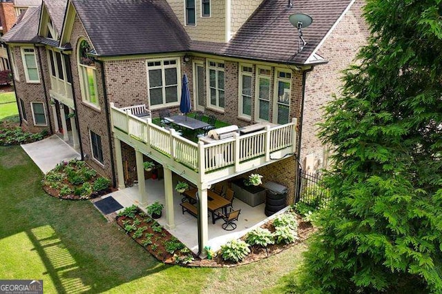 rear view of property with a yard, a patio, and a deck