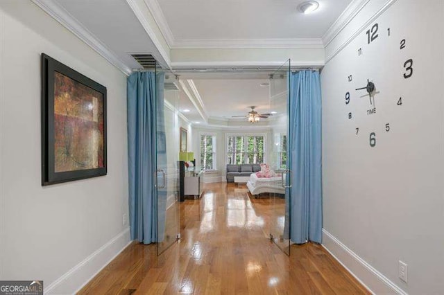 hallway featuring wood-type flooring and crown molding