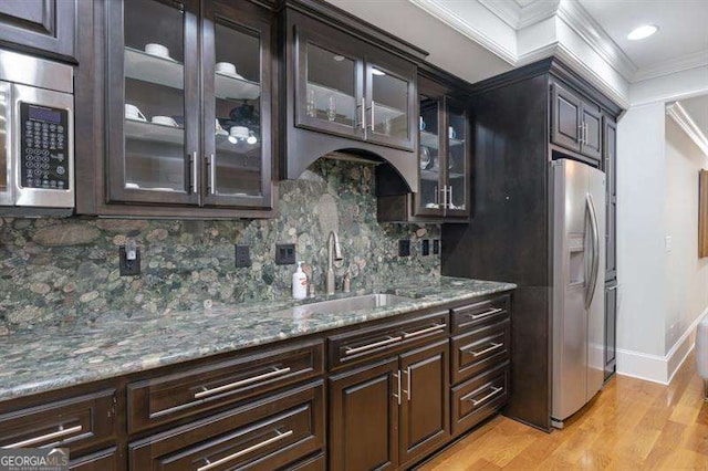 kitchen with sink, stainless steel appliances, tasteful backsplash, light wood-type flooring, and ornamental molding