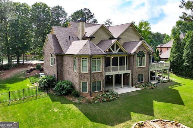 rear view of house featuring a patio area and a yard