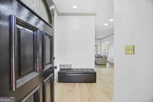 entrance foyer featuring light hardwood / wood-style flooring and ornamental molding