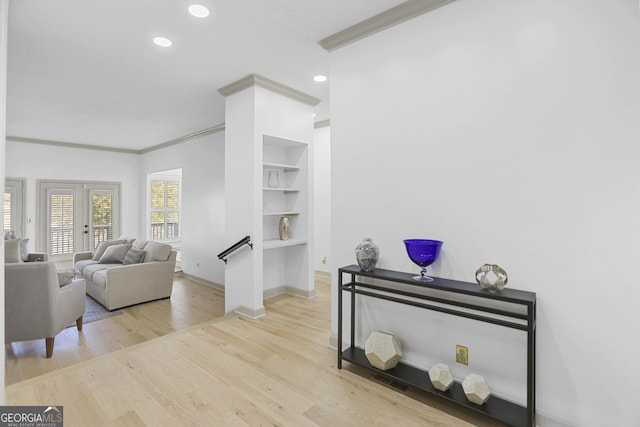 living room with french doors, light hardwood / wood-style floors, and ornamental molding