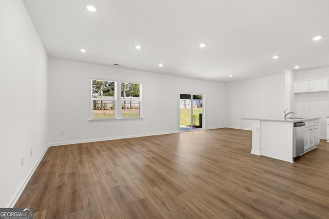 unfurnished living room with hardwood / wood-style floors and sink