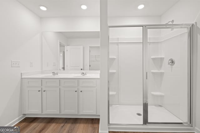 bathroom featuring vanity, wood-type flooring, and a shower with shower door