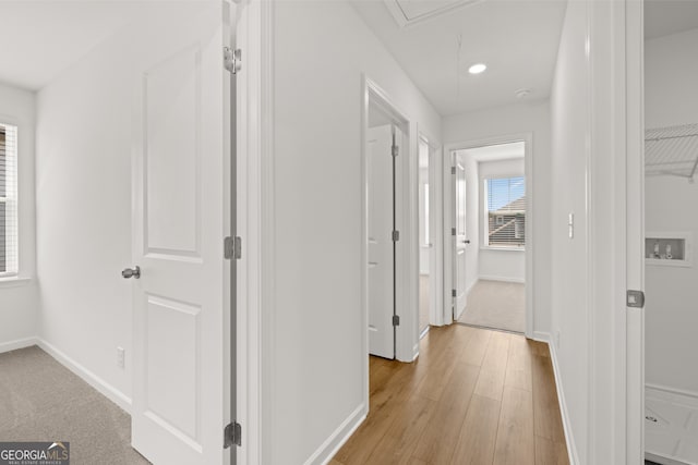 corridor with light hardwood / wood-style floors