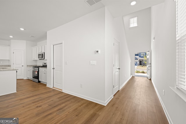 hallway with plenty of natural light and hardwood / wood-style flooring