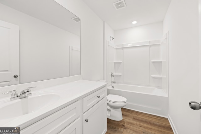 full bathroom with shower / bathing tub combination, vanity, hardwood / wood-style flooring, and toilet