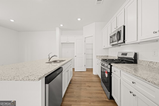 kitchen with white cabinets, sink, light wood-type flooring, and stainless steel appliances