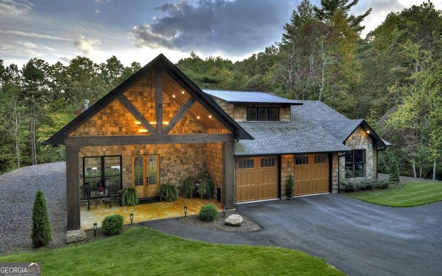 view of front of house with a yard, french doors, and a garage