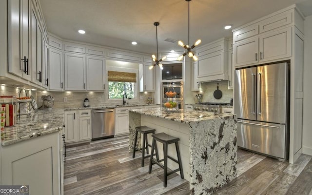 kitchen featuring a chandelier, dark hardwood / wood-style flooring, stainless steel appliances, and a kitchen island