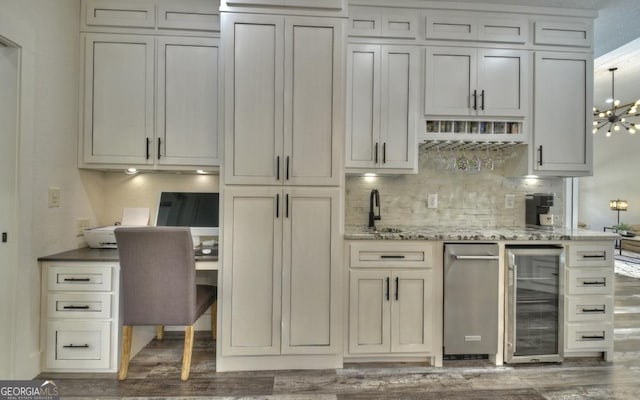 kitchen with dark hardwood / wood-style floors, light stone countertops, beverage cooler, and a chandelier