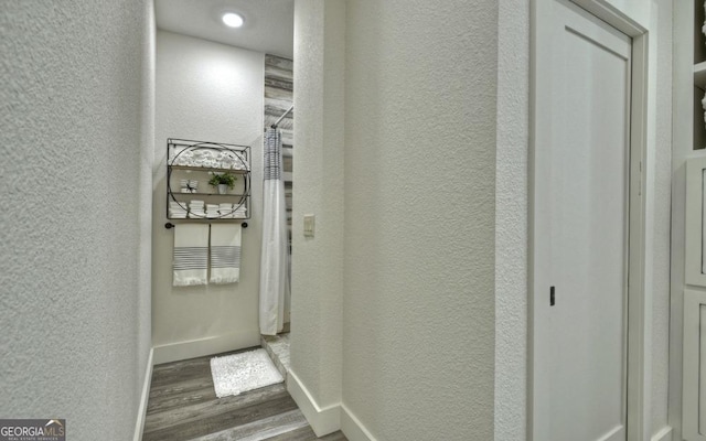 corridor with dark hardwood / wood-style flooring