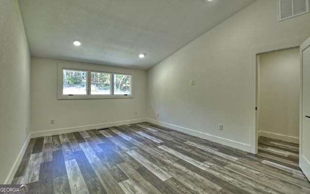 spare room featuring hardwood / wood-style floors and a textured ceiling