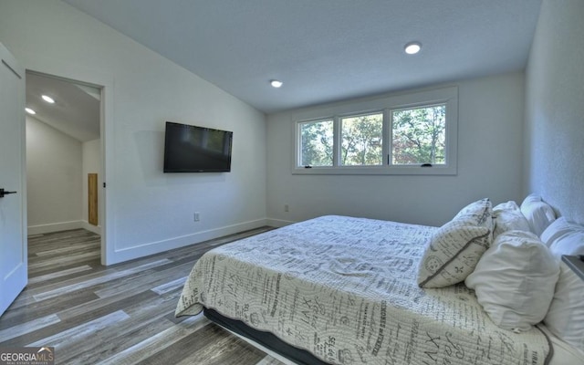 bedroom featuring wood-type flooring and vaulted ceiling