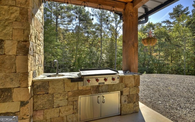 view of patio / terrace with grilling area, sink, and an outdoor kitchen