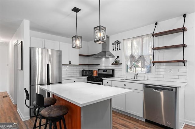 kitchen with a center island, sink, stainless steel appliances, extractor fan, and white cabinets