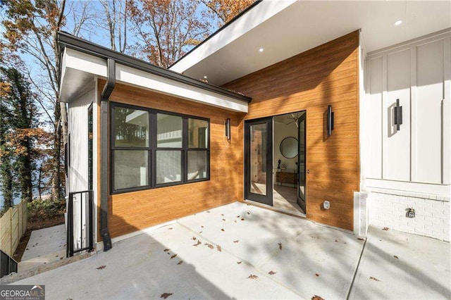 doorway with french doors, light hardwood / wood-style floors, vaulted ceiling, and an inviting chandelier