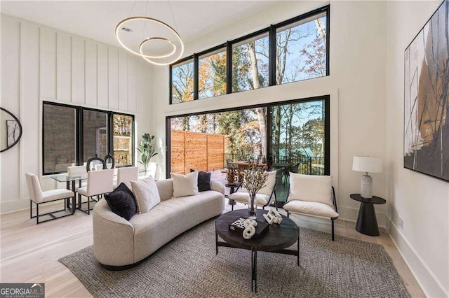 living room with a towering ceiling and light hardwood / wood-style floors