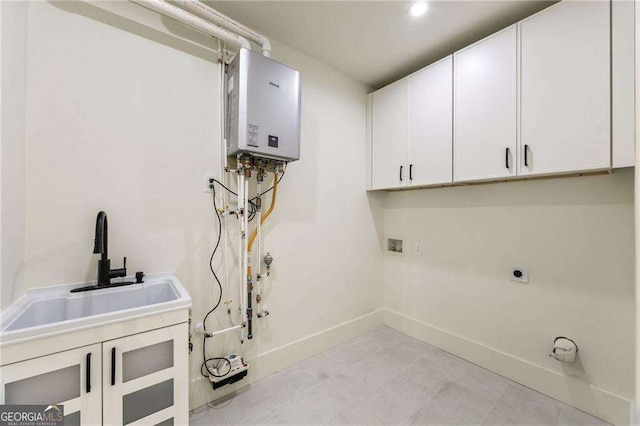 laundry area with cabinets, washer hookup, electric dryer hookup, sink, and tankless water heater