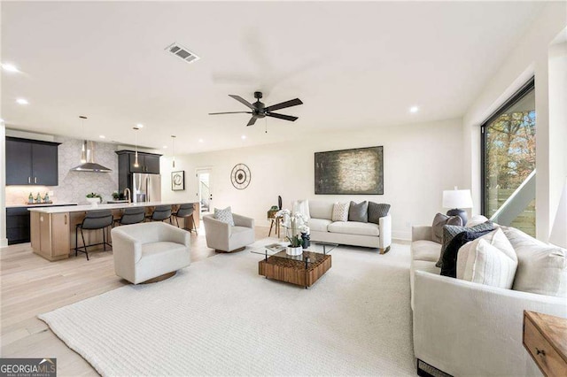 living room featuring light hardwood / wood-style flooring and ceiling fan