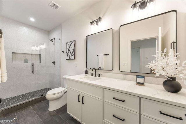 bathroom with tile patterned flooring, vanity, an enclosed shower, and toilet