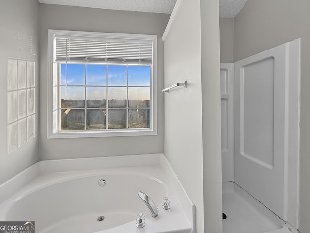 bathroom featuring a textured ceiling and independent shower and bath