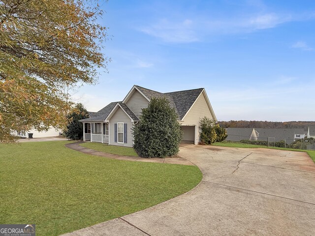 231 Ferguson Ave, Locust Grove, GA 30248 - view of side of property with a garage, a yard, concrete driveway, and roof with shingles