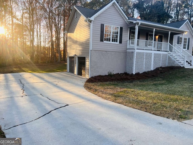 view of front of home featuring a porch, a garage, and a yard