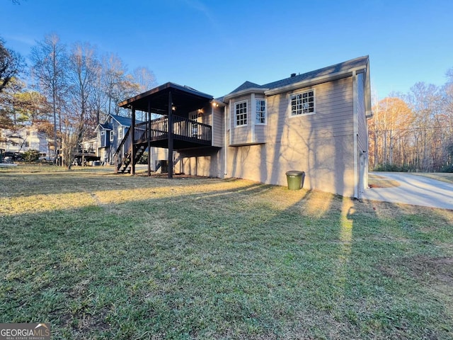 back of property featuring a yard and a wooden deck