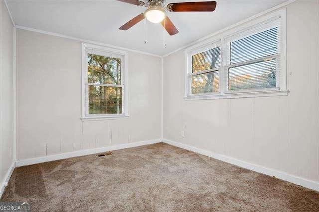 carpeted spare room with ceiling fan and crown molding