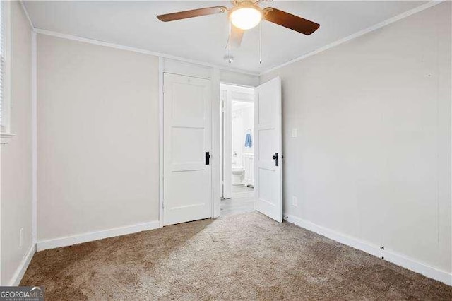 unfurnished bedroom featuring carpet floors, ceiling fan, and crown molding