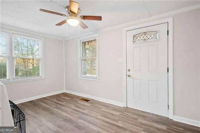 entrance foyer featuring light hardwood / wood-style floors, ceiling fan, and ornamental molding