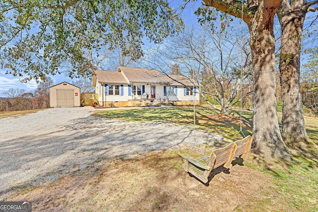 single story home featuring a shed and a front lawn